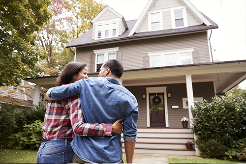 couple standing in front of house